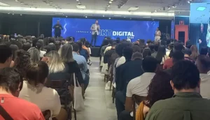 Palestrantes renomados no palco da Jornada de Marketing Digital em Cuiabá, com plateia engajada e telão com o tema do evento e logo do Sebrae/MT.